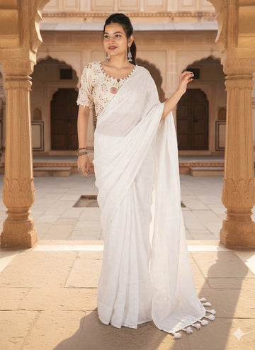 Woman in a white saree standing in an architectural setting